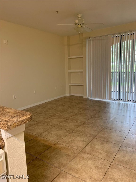 Unfurnished room with ceiling fan, baseboards, bui