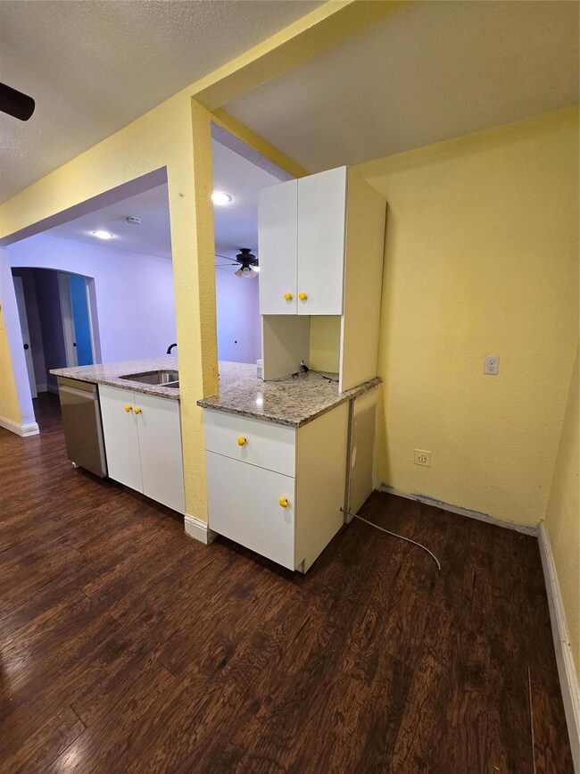 Kitchen featuring ceiling fan, white cabinets, dar