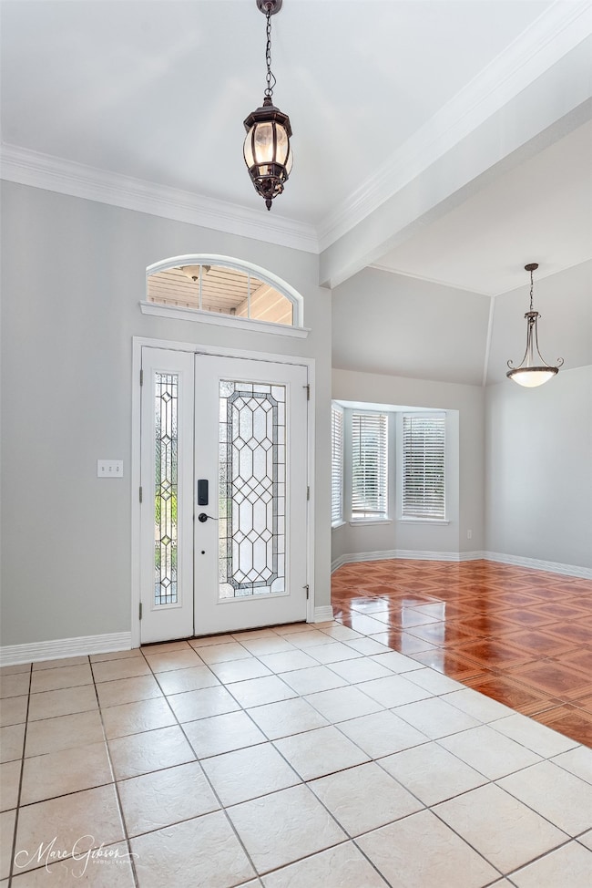 Foyer featuring light tile patterned floors and ornamental molding