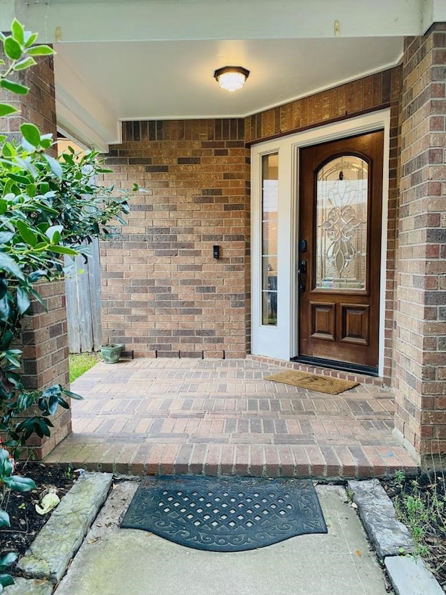 All brick design covered Porch leads up to the rich stained front door with recess lighting. Welcome! Come on in...