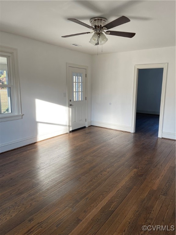 Unfurnished room featuring ceiling fan and dark ha