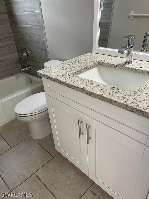 Full bathroom featuring  shower combination, vanity, toilet, and tile floors
