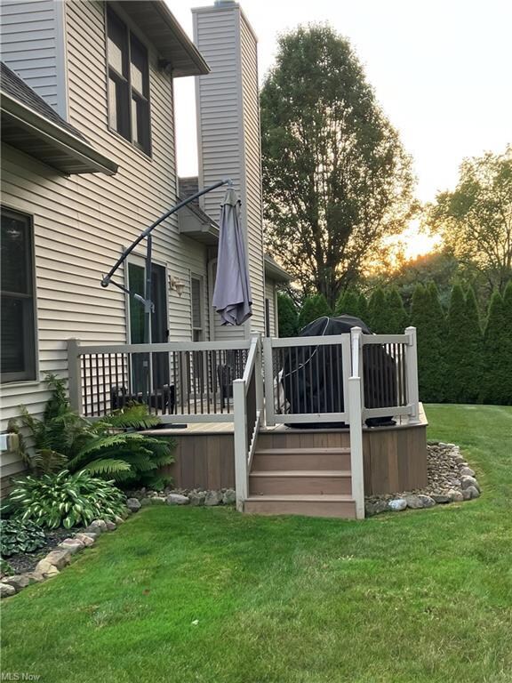 Wooden terrace featuring a yard