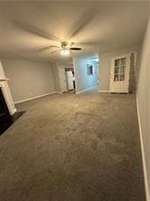 Unfurnished living room featuring carpet floors, ceiling fan, and a large fireplace