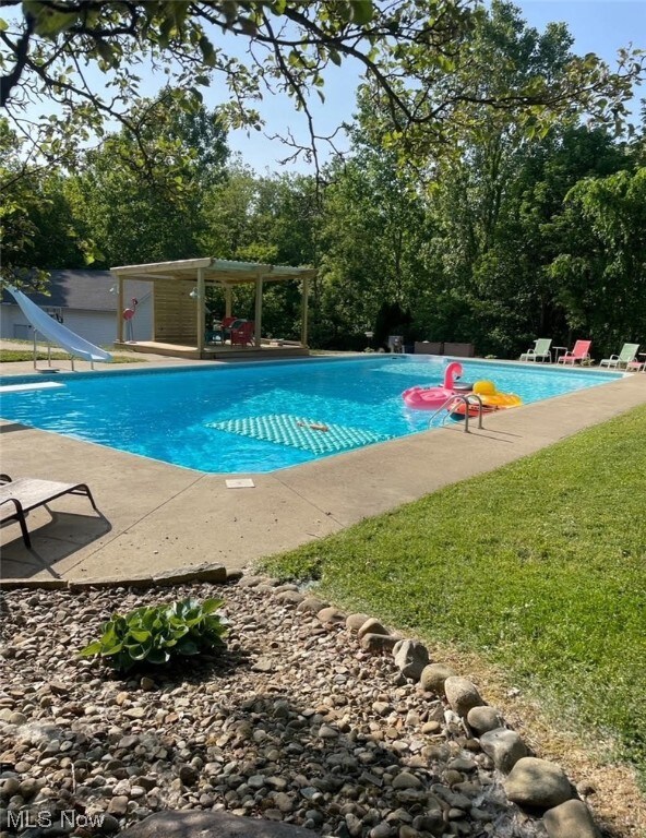 View of swimming pool with a water slide
