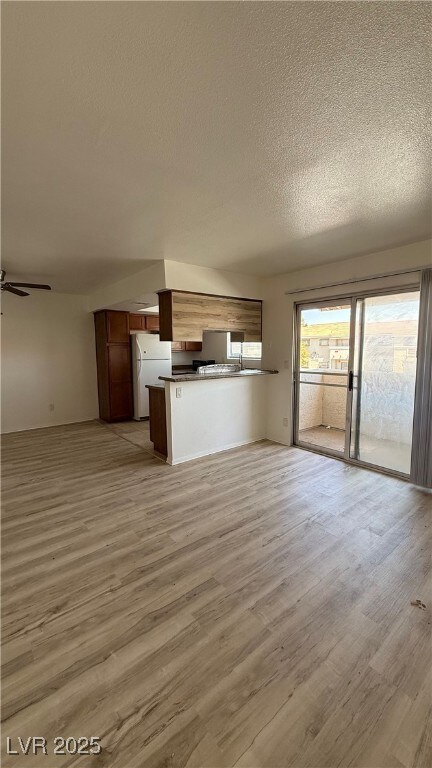 Unfurnished living room with a textured ceiling, l