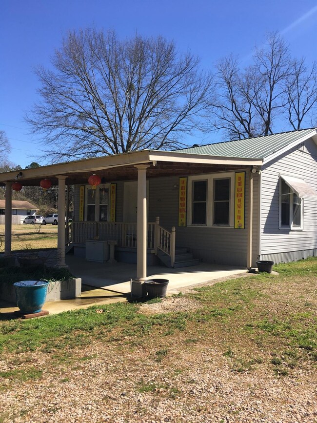 Back of property with covered porch, a yard, metal