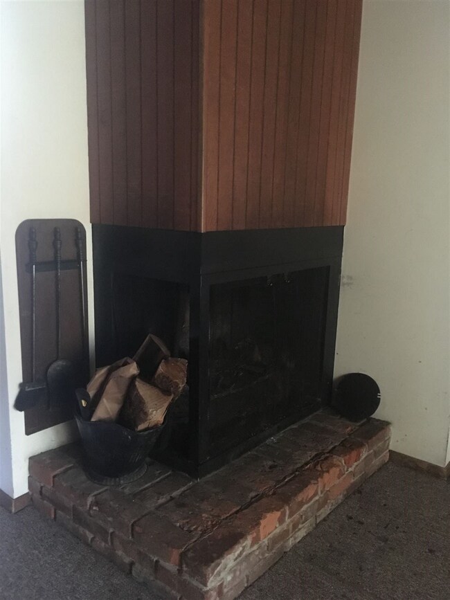 A stunning wood fireplace provides warmth and a ce