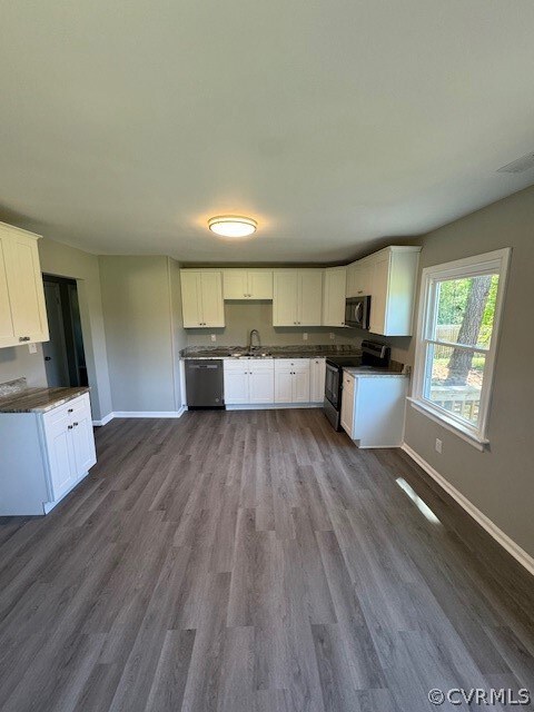 Kitchen featuring stove, dark wood-type flooring,