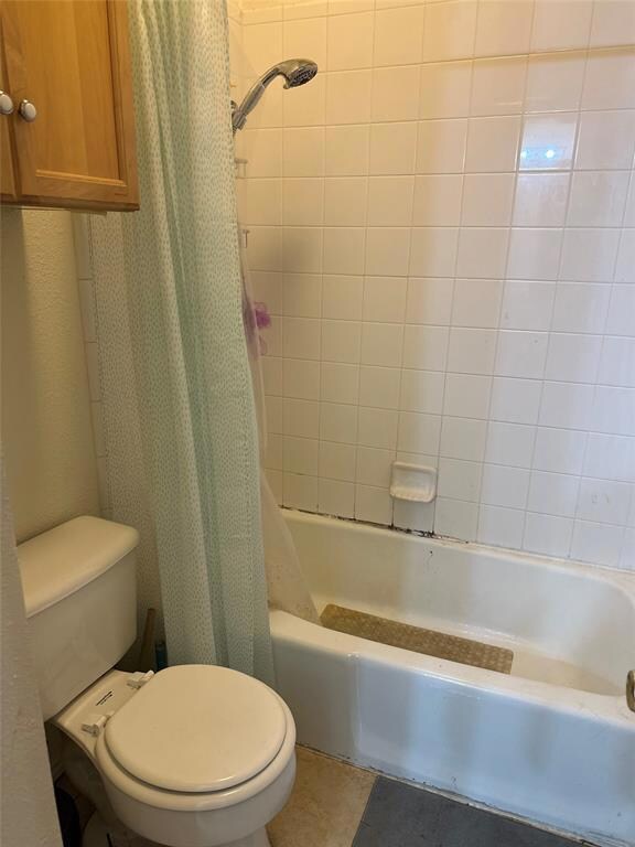 Full bathroom with toilet and shower / bath combo