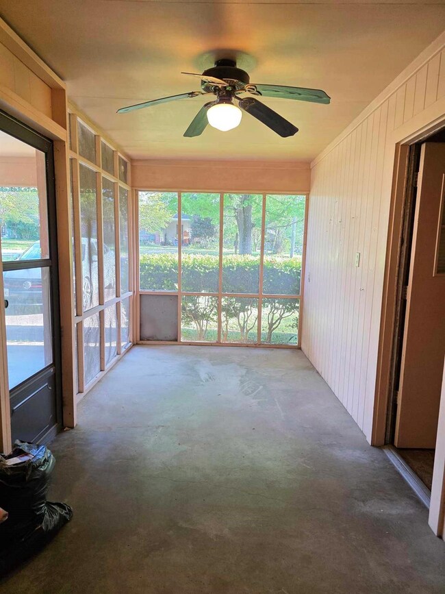 Unfurnished sunroom featuring a ceiling fan