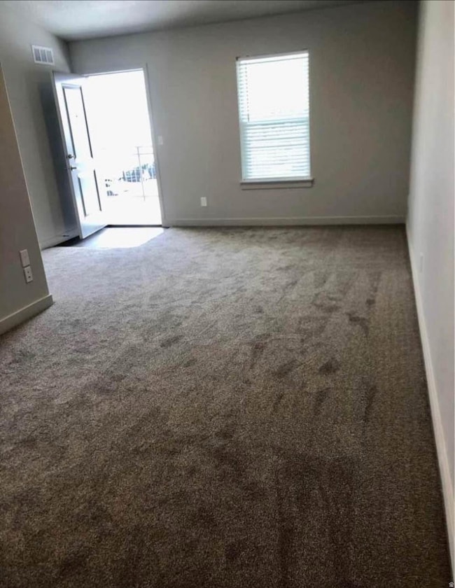 Unfurnished room with carpet and baseboards