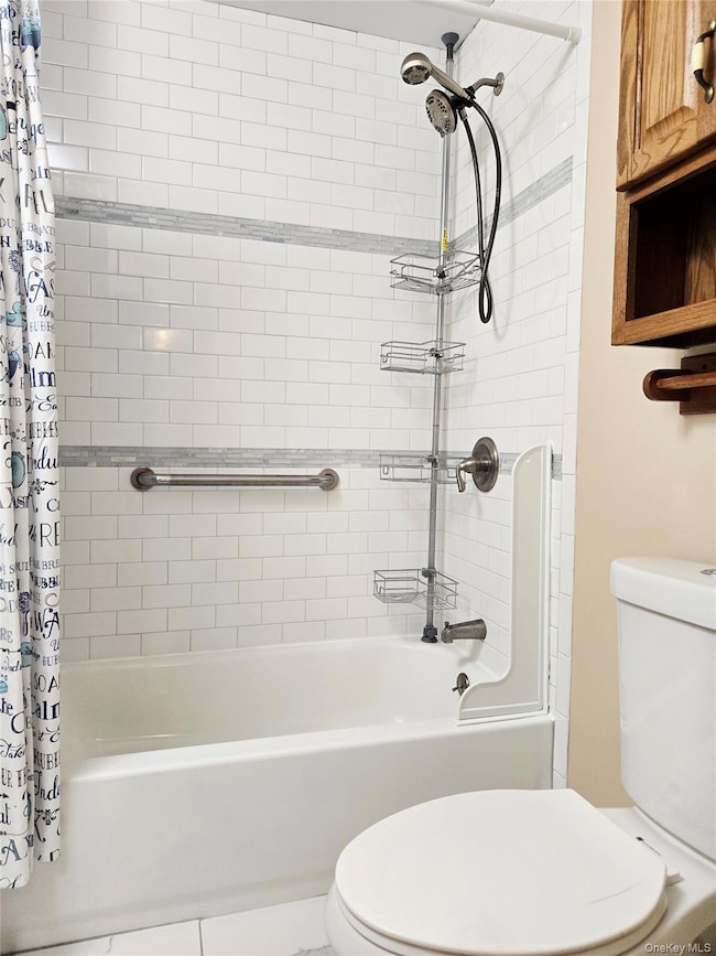Bathroom with shower / bath combo with shower curtain and tile patterned floors