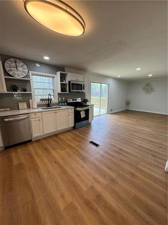 Kitchen featuring a sink, open shelves, stainless 