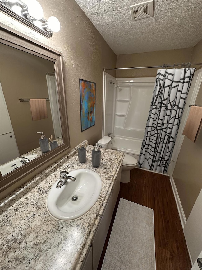 Full bath featuring toilet, wood finished floors, 