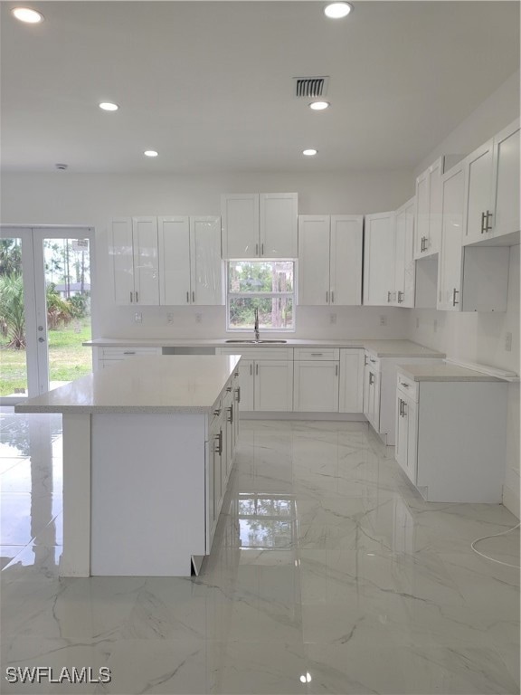 Kitchen with light marble finish flooring, recesse