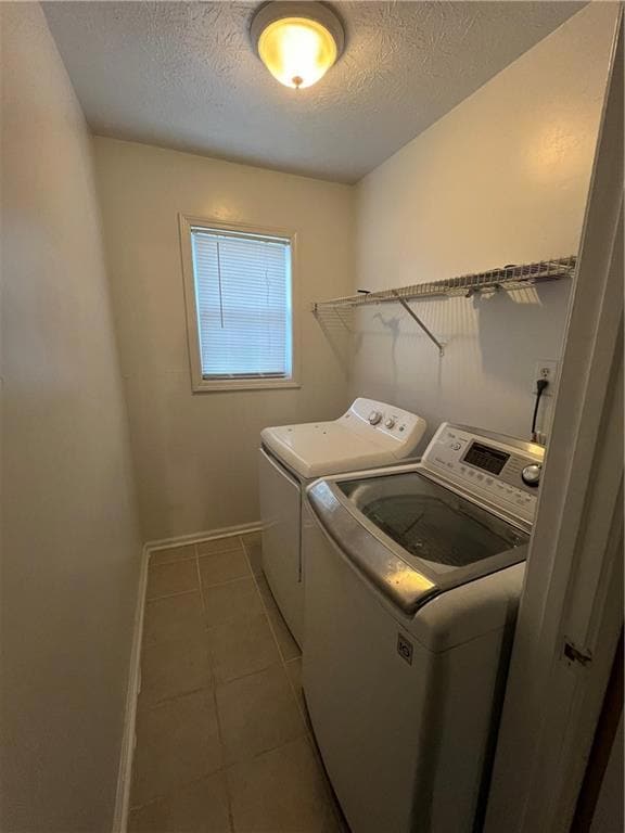 Washroom with baseboards, laundry area, a textured