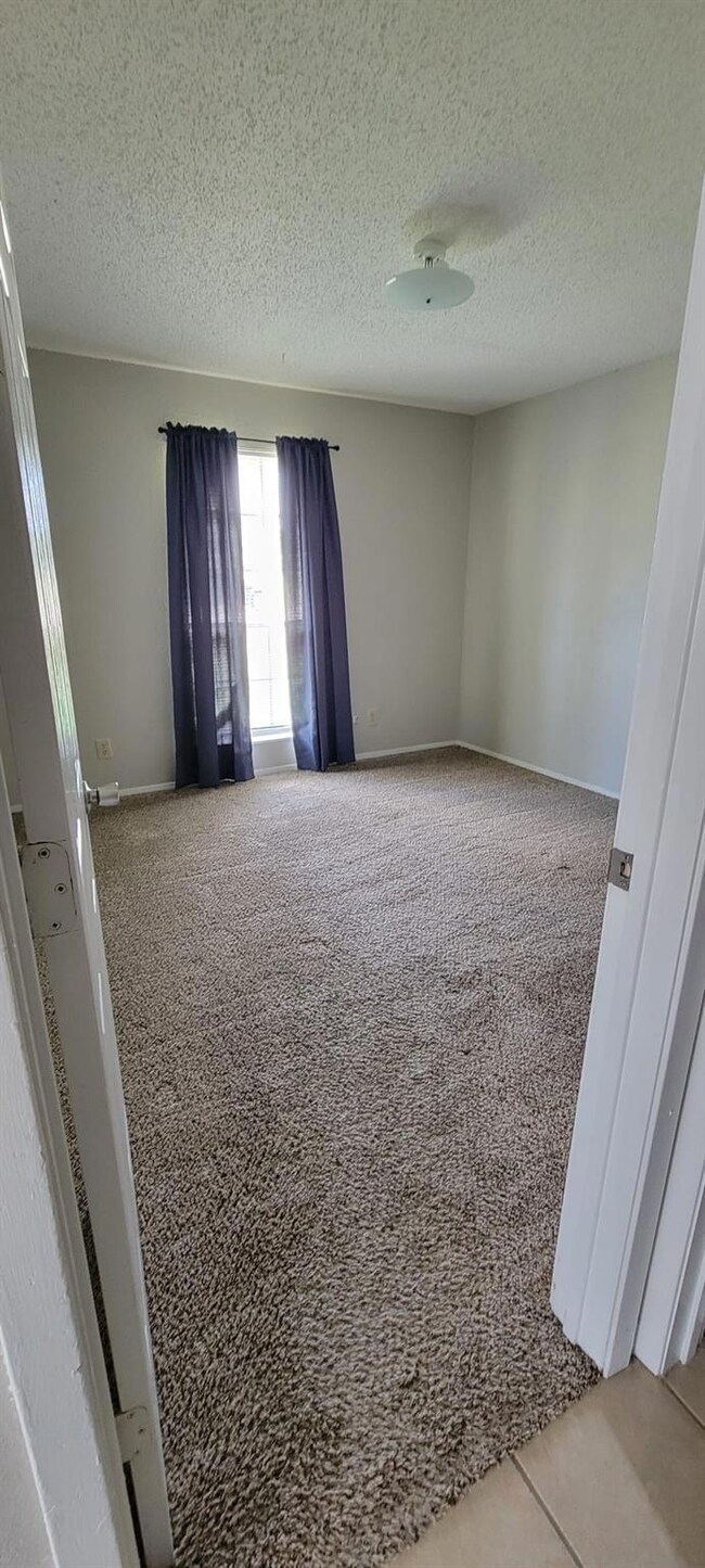 Carpeted empty room featuring a textured ceiling