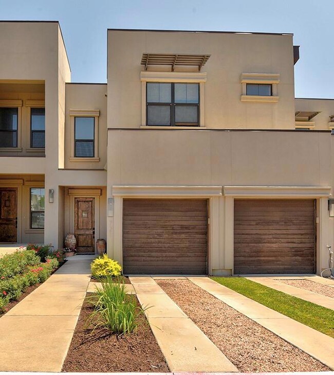 View of front facade featuring a garage and stucc