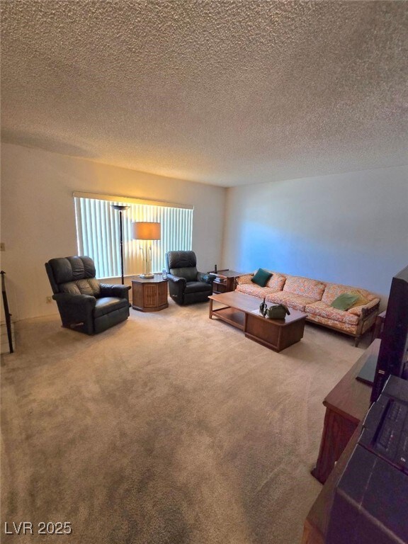 Carpeted living room featuring a textured ceiling
