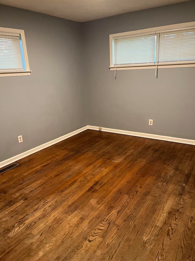 Unfurnished room featuring dark wood-style floors