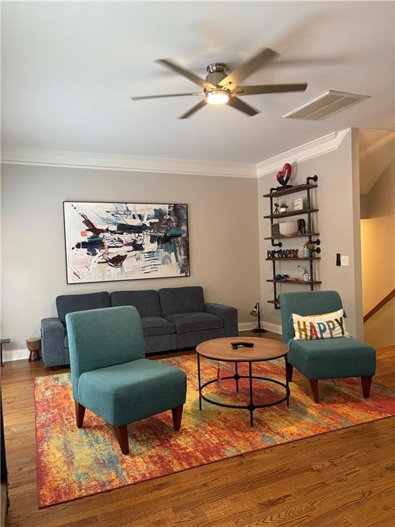 Living room with wood finished floors, crown molding, and a ceiling fan