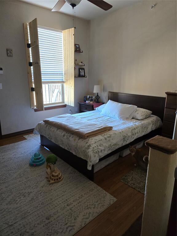 Bedroom with ceiling fan and dark hardwood / wood-