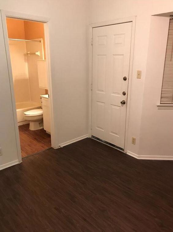 Foyer entrance with baseboards and dark wood-type