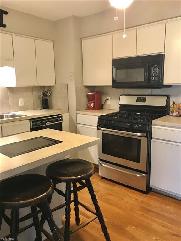 Eat in kitchen with stainless gas stove and microw
