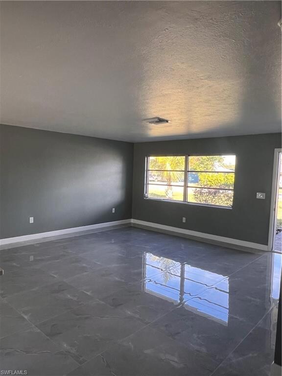 Unfurnished room with a textured ceiling