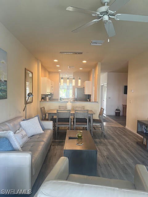 Living room with wood finished floors, a ceiling f