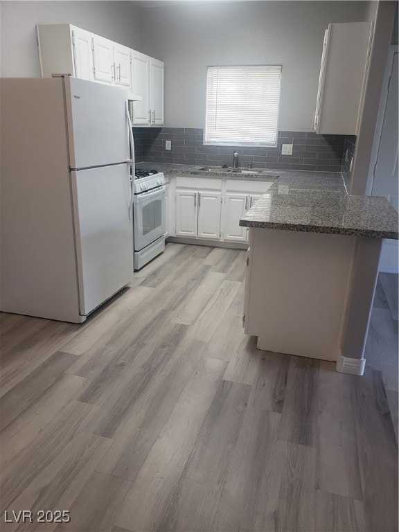 Kitchen with fridge, range, a peninsula, and stone