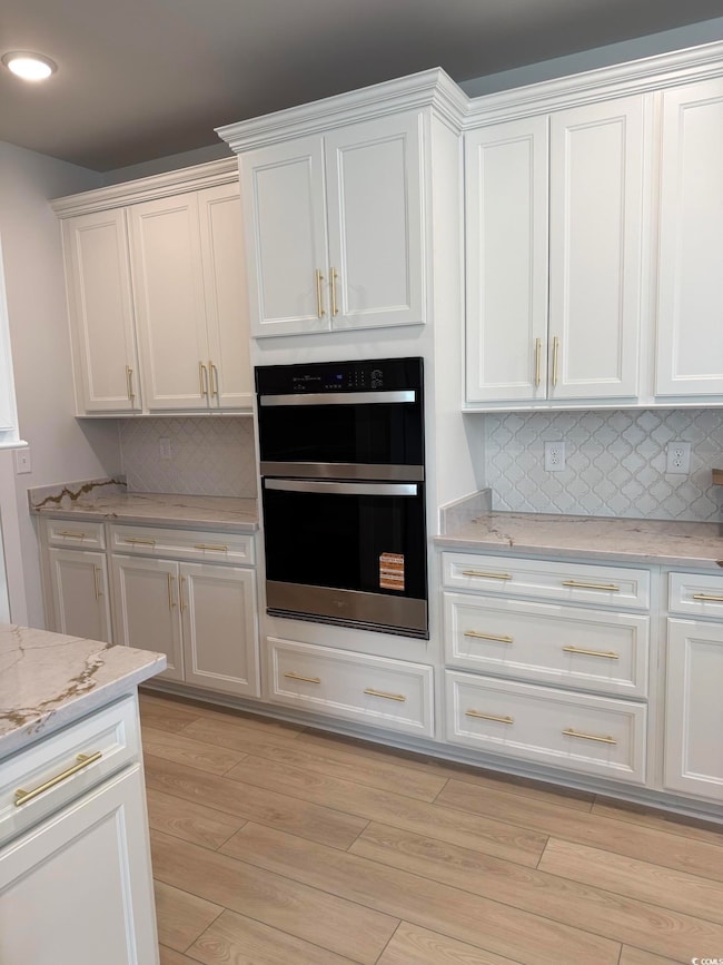 Kitchen featuring white cabinets, dobule oven blac