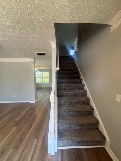 Stairway featuring visible vents, baseboards, a te