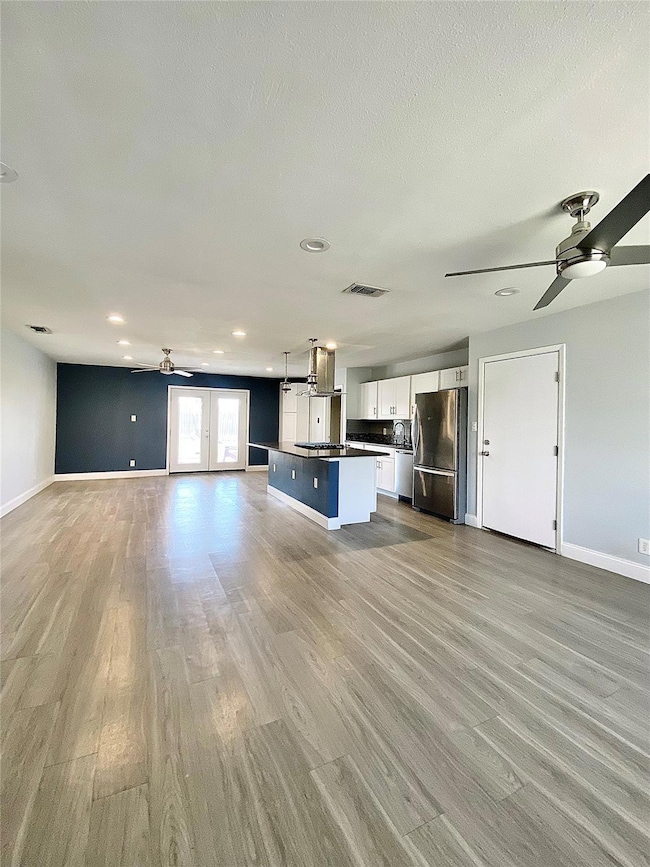 Unfurnished living room featuring a ceiling fan, 