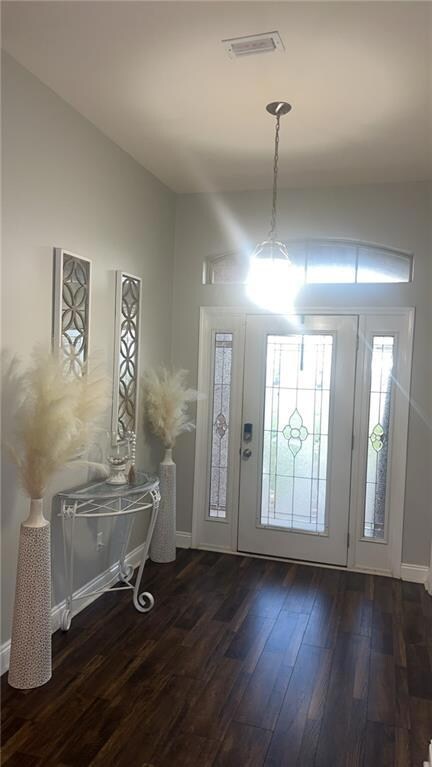 Foyer entrance with visible vents, baseboards, and