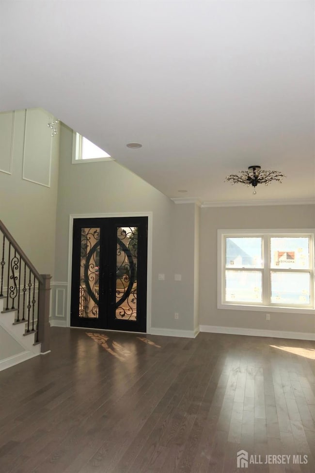 Entrance foyer with stairs, dark wood-type flooring, and french doors