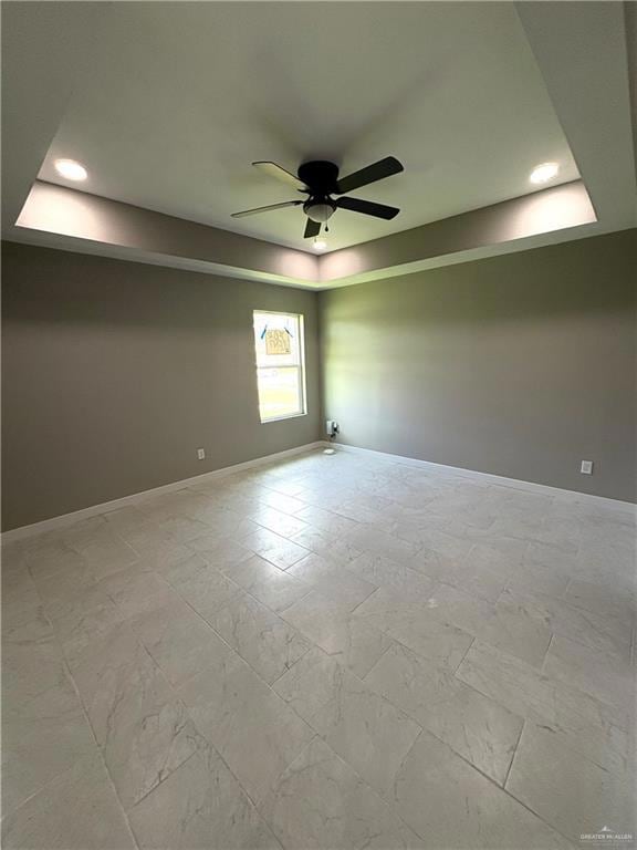 Unfurnished room with a raised ceiling, a ceiling fan, and recessed lighting