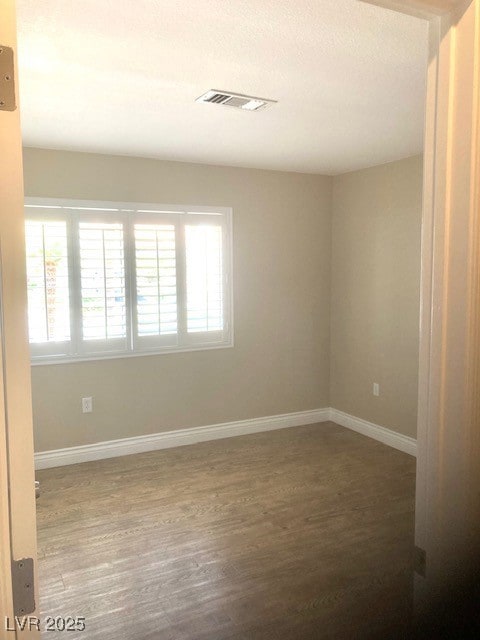 Spare room with wood finished floors, plenty of na