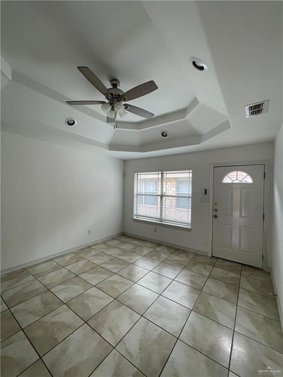 Foyer entrance featuring a raised ceiling, ceiling fan, light tile patterned floors, and recessed lighting