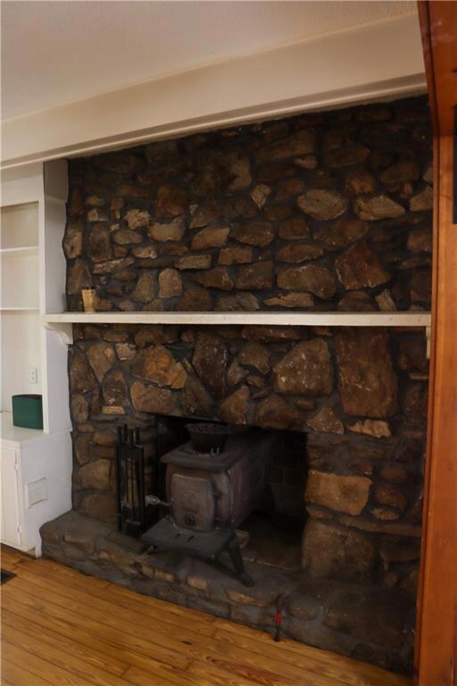 Room details with a wood stove, hardwood / wood-st