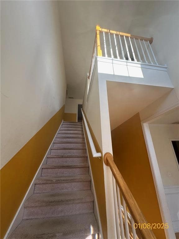 Staircase featuring a towering ceiling