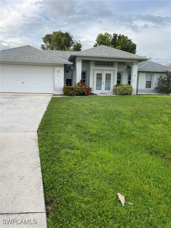 View of front facade with a front lawn, a garage,
