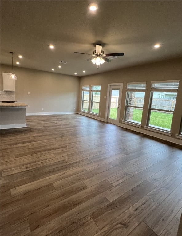 Unfurnished living room featuring wood finished fl
