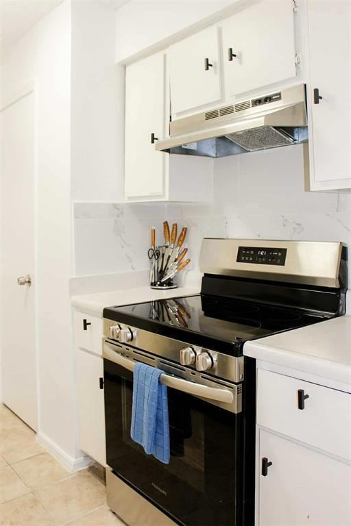 Kitchen featuring stainless steel range with electric cooktop, light countertops, white cabinetry, and under cabinet range hood
