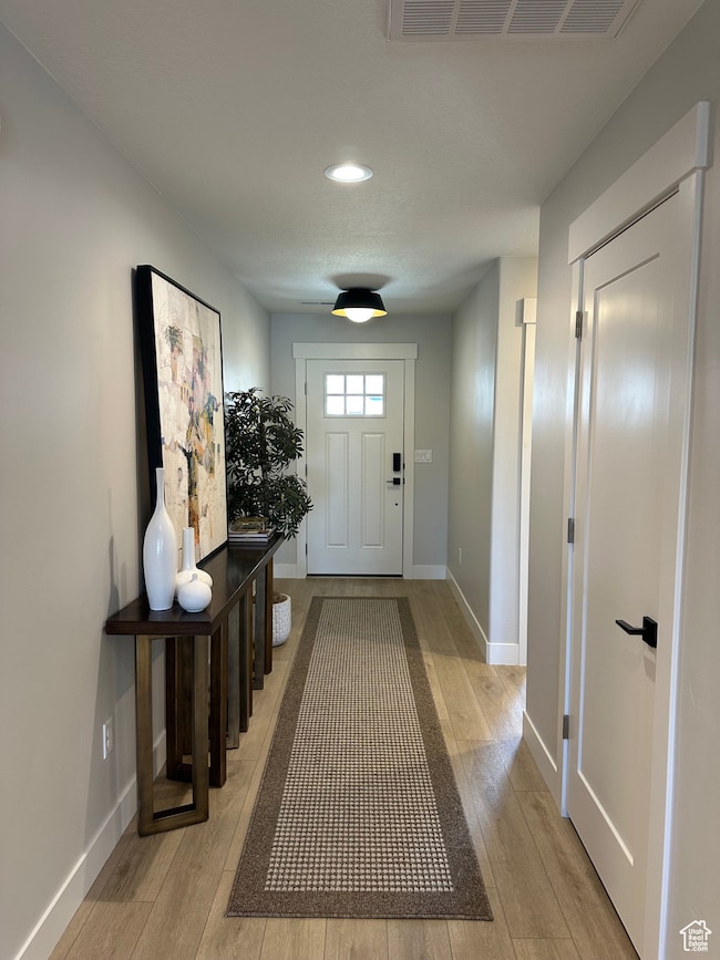 Doorway to outside featuring wood-type flooring and recessed lighting
