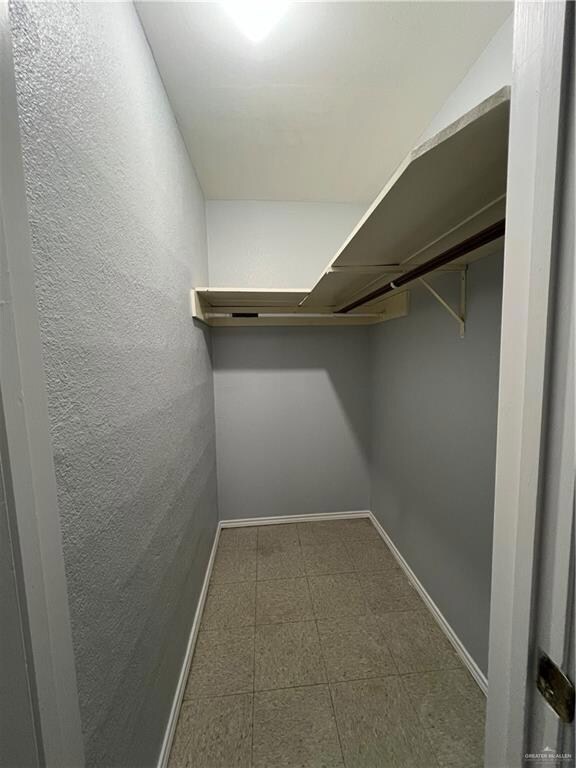 Spacious closet featuring dark flooring