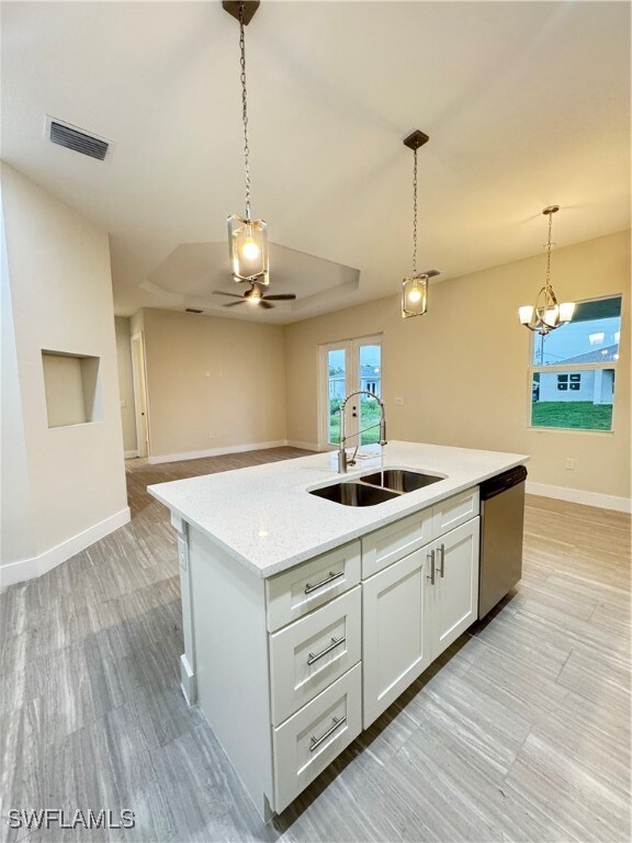 Kitchen featuring a sink, dishwasher, pendant ligh