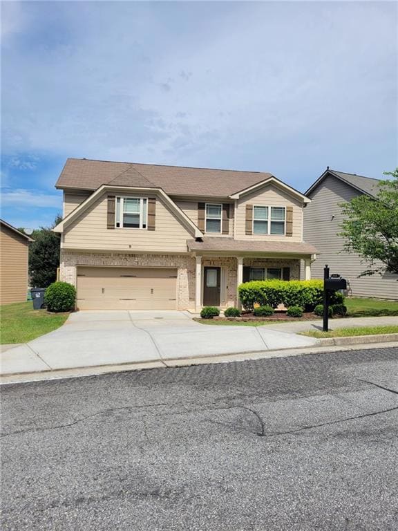 View of front of house featuring driveway, brick siding, and a garage