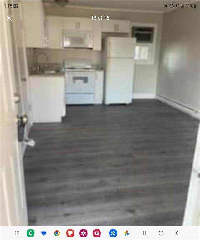 Kitchen with white appliances, white cabinetry, da